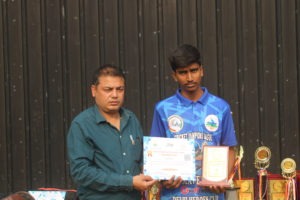 A proud cricket player lifting a trophy after a victorious match